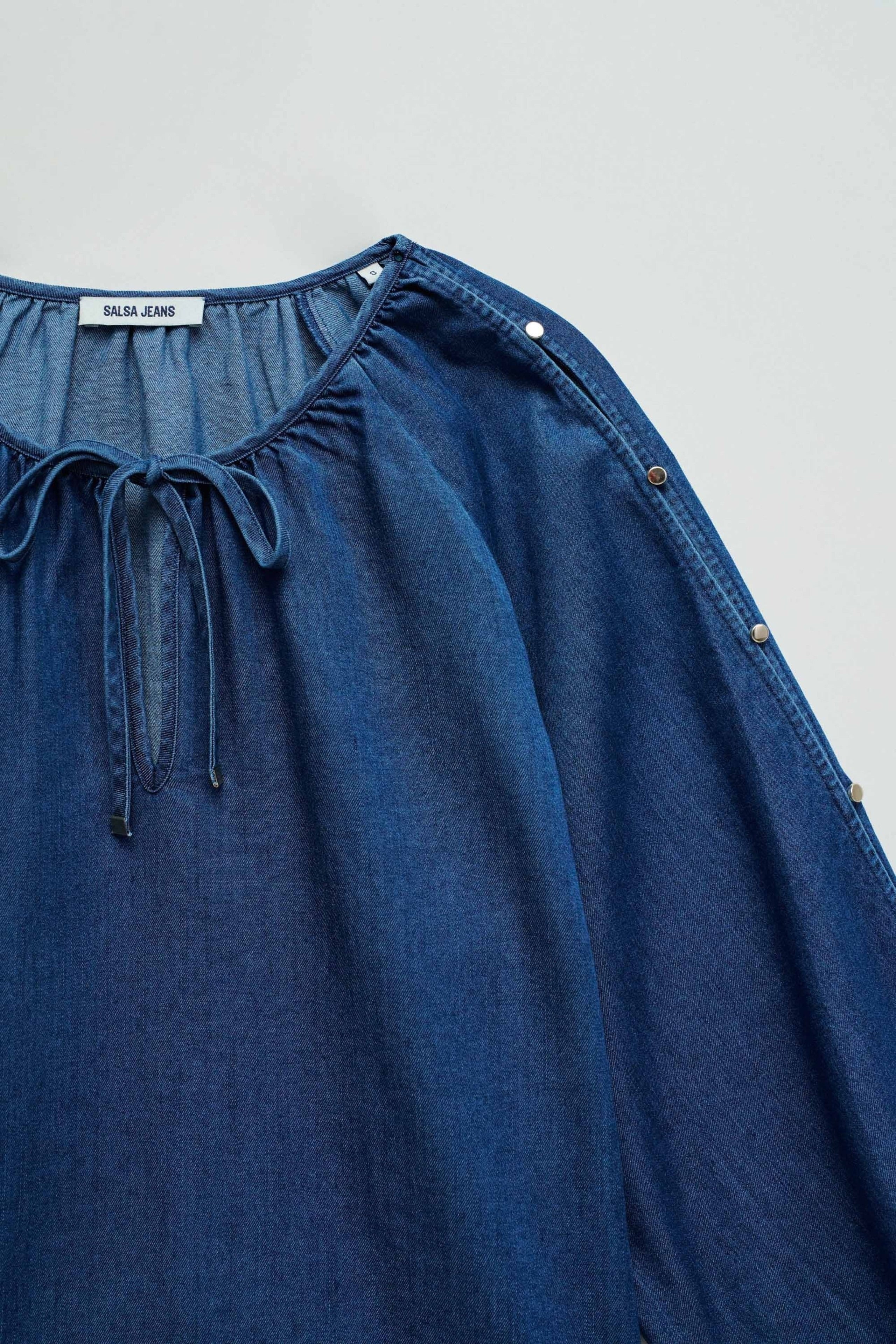 Détail des manches de la blouse en délavé foncé